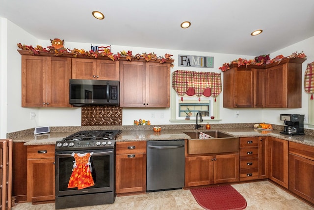 kitchen featuring sink, stone countertops, and stainless steel appliances