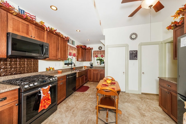 kitchen with tasteful backsplash, light stone countertops, sink, ceiling fan, and stainless steel appliances