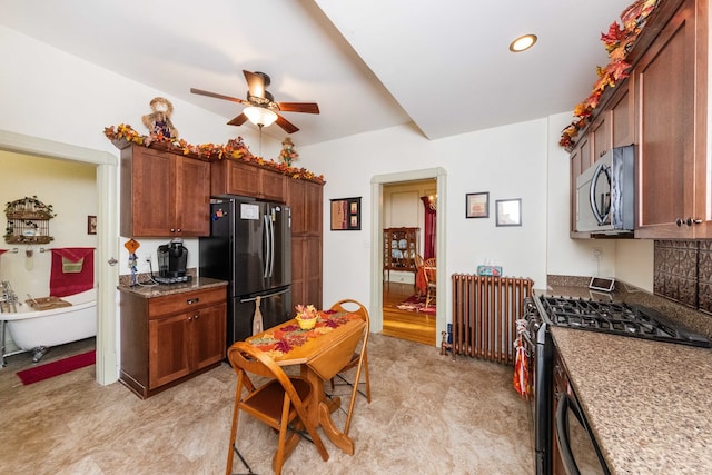 kitchen with light carpet, decorative backsplash, ceiling fan, appliances with stainless steel finishes, and stone countertops