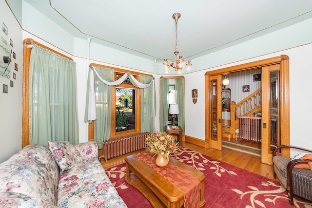 living room featuring radiator heating unit, a chandelier, and hardwood / wood-style floors