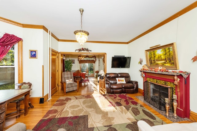 living room with ornamental molding, a chandelier, and light wood-type flooring