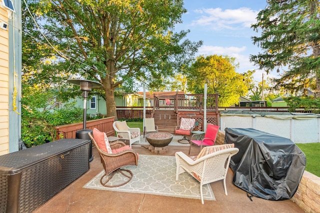 view of patio / terrace featuring area for grilling, a deck, and a fire pit