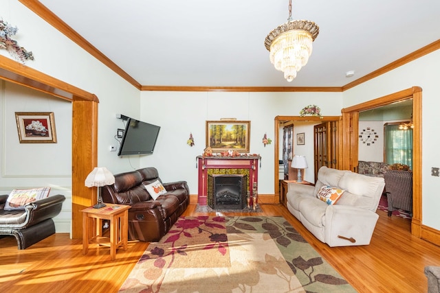 living room with an inviting chandelier, crown molding, and hardwood / wood-style floors