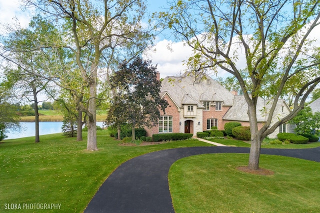 view of front of property with a water view and a front lawn