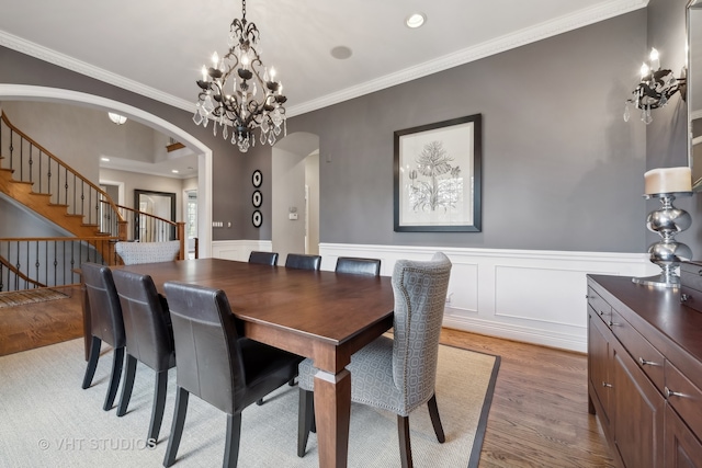 dining area with an inviting chandelier, light hardwood / wood-style floors, and ornamental molding