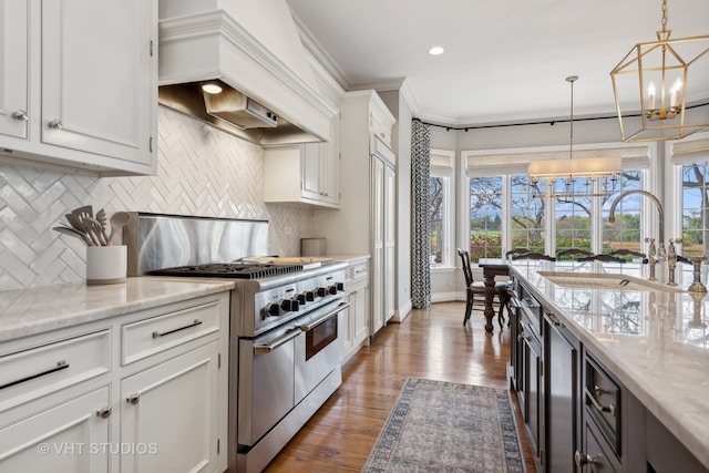 kitchen featuring white cabinets, pendant lighting, and high end stainless steel range