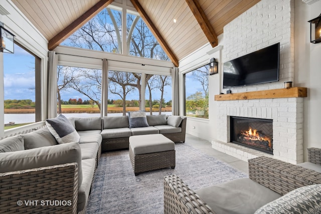 tiled living room featuring a healthy amount of sunlight, a water view, and a brick fireplace