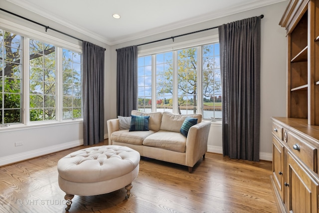 living area with light hardwood / wood-style flooring and ornamental molding