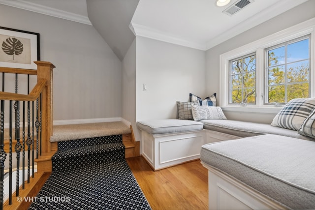 bedroom featuring vaulted ceiling, light hardwood / wood-style flooring, and ornamental molding