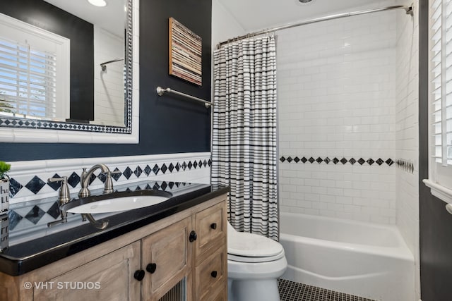 full bathroom featuring vanity, tile patterned floors, shower / bath combination with curtain, toilet, and tile walls