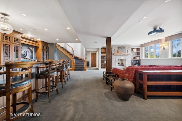 interior space featuring a fireplace, built in shelves, carpet flooring, and bar