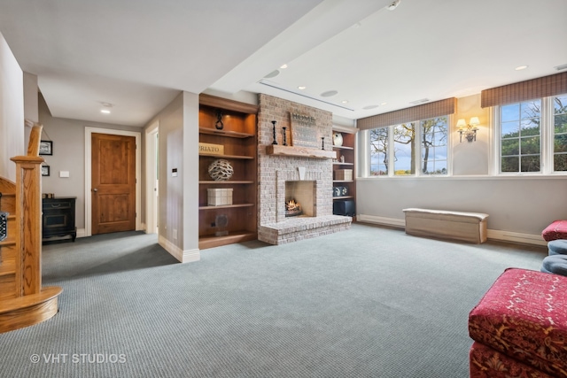 living room with carpet flooring, built in features, and a fireplace