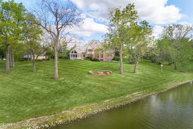 view of yard featuring a fire pit and a water view