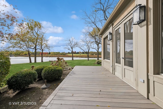 wooden deck featuring a lawn and a water view