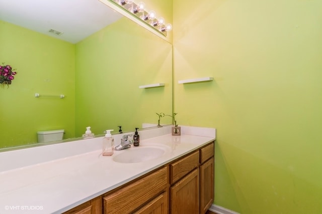 bathroom featuring vanity and toilet