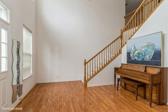 interior space featuring a towering ceiling and hardwood / wood-style flooring