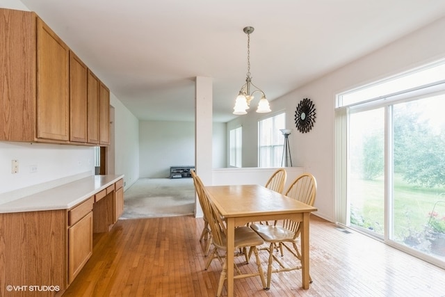 dining area featuring light wood-type flooring, a chandelier, and a wealth of natural light