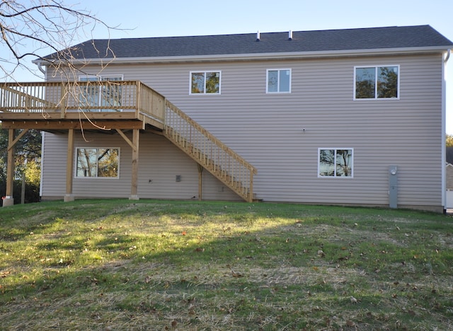 back of property featuring a lawn and a wooden deck