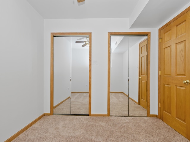 unfurnished bedroom with light carpet and multiple closets