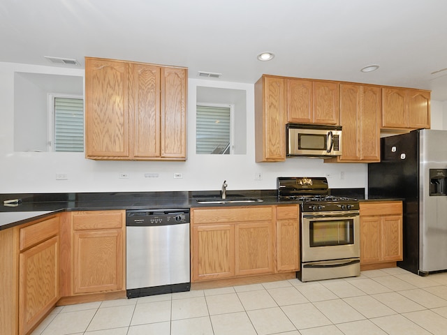 kitchen with light tile patterned floors, appliances with stainless steel finishes, and sink