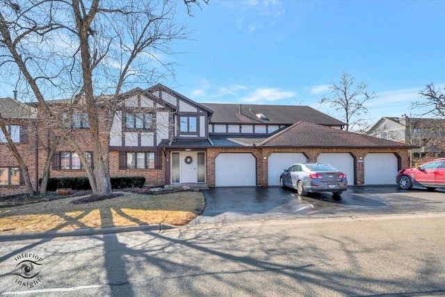 view of front of house featuring a garage, brick siding, driveway, and roof with shingles