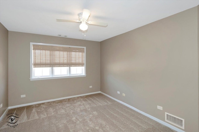 empty room featuring light colored carpet, visible vents, ceiling fan, and baseboards