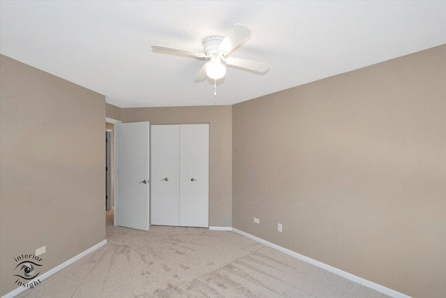 unfurnished bedroom featuring a ceiling fan, a closet, light colored carpet, and baseboards