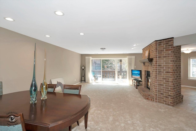 living room with recessed lighting, light colored carpet, a fireplace, and baseboards