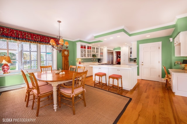 dining area featuring crown molding, a chandelier, and light wood-type flooring