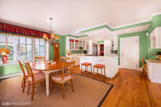 dining space featuring an inviting chandelier, ornamental molding, recessed lighting, and light wood-style flooring