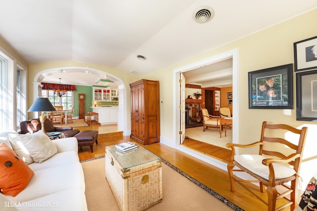 living room featuring a chandelier, hardwood / wood-style flooring, and lofted ceiling