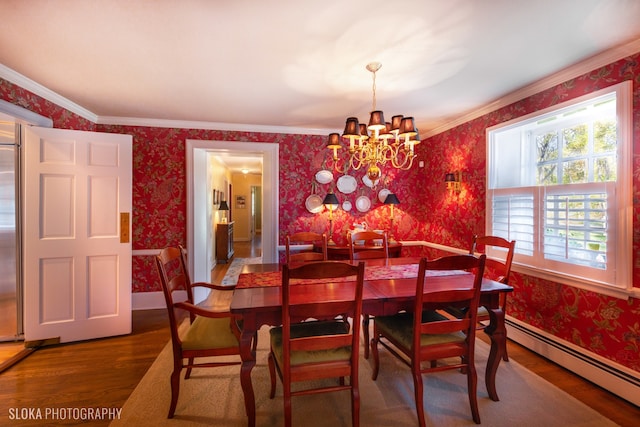 dining room with a baseboard heating unit, wood-type flooring, crown molding, and a chandelier