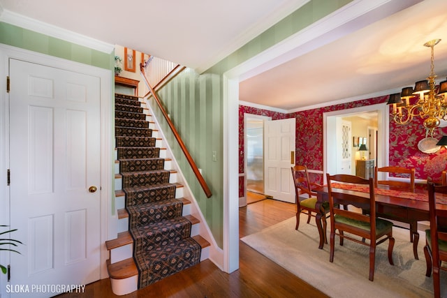 interior space featuring crown molding, hardwood / wood-style floors, and a notable chandelier