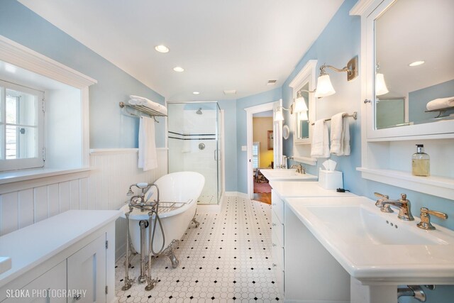 full bath featuring a freestanding bath, wainscoting, tile patterned floors, recessed lighting, and a shower stall