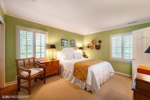 bedroom featuring light colored carpet and ornamental molding