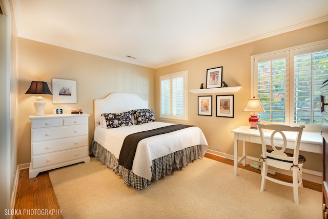 bedroom featuring hardwood / wood-style flooring, multiple windows, and ornamental molding