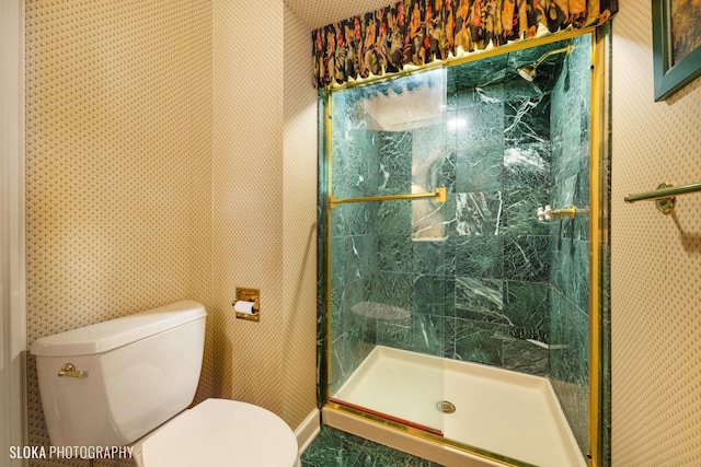 full bathroom with toilet, wallpapered walls, and a shower stall