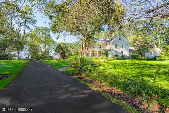 exterior space with a chimney and a front lawn