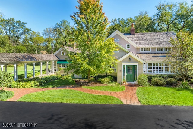 view of front of property with a chimney and a front yard
