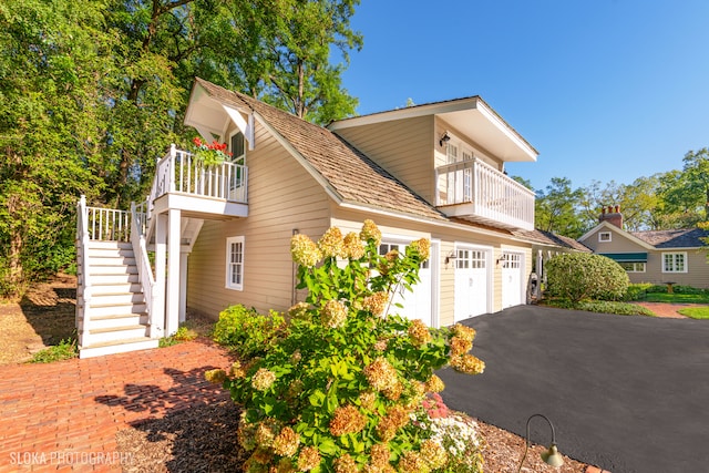 view of front of property featuring a balcony and a garage