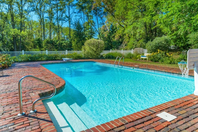 view of swimming pool featuring a fenced in pool, a fenced backyard, and a patio area