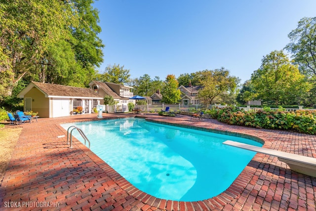 view of pool with fence, an outbuilding, a patio area, and a fenced in pool