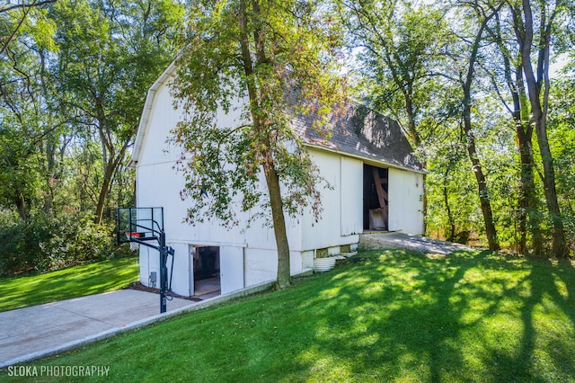 view of home's exterior with a yard and basketball court