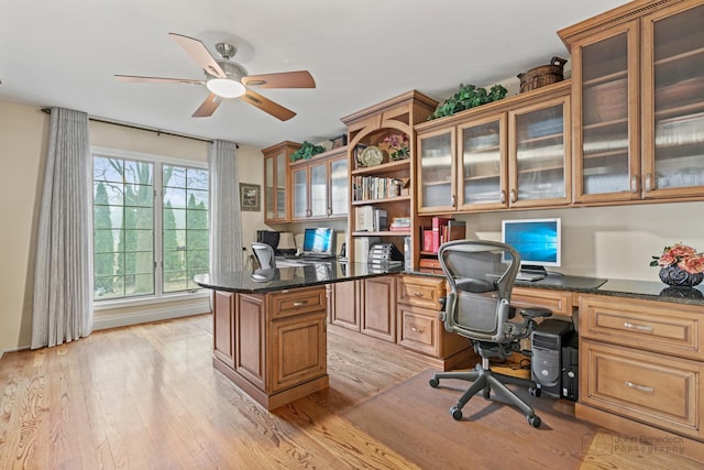 office with built in desk, light hardwood / wood-style flooring, and ceiling fan