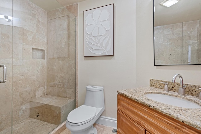 bathroom featuring vanity, an enclosed shower, and toilet