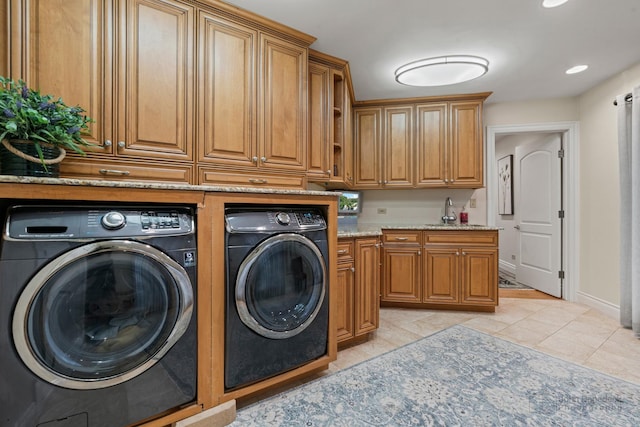 clothes washing area featuring cabinets, sink, independent washer and dryer, and light tile patterned floors