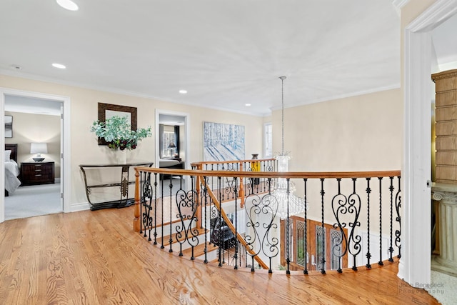 hall featuring ornamental molding, a chandelier, and light hardwood / wood-style floors