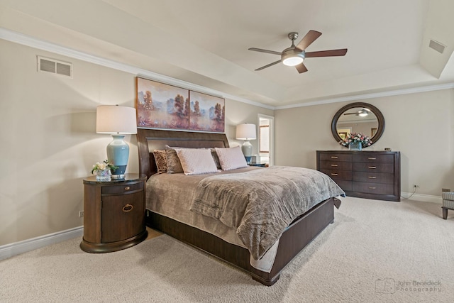 carpeted bedroom with crown molding, ceiling fan, and a raised ceiling