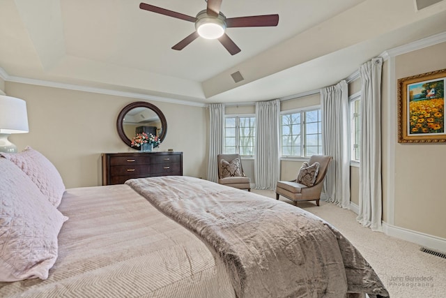 carpeted bedroom with crown molding, ceiling fan, and a raised ceiling