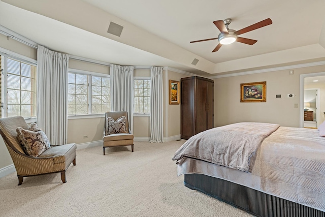 bedroom with ceiling fan, a tray ceiling, and light carpet